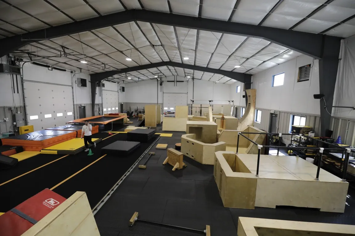 The full parkour floor at HUB Norfolk, with wooden obstacles on new black flooring