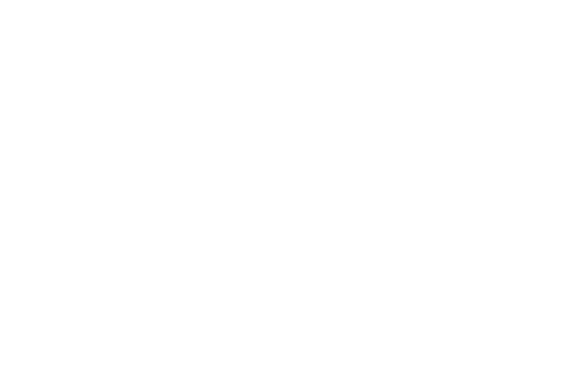 Modern multi-story office building at street corner with large windows and street lamps