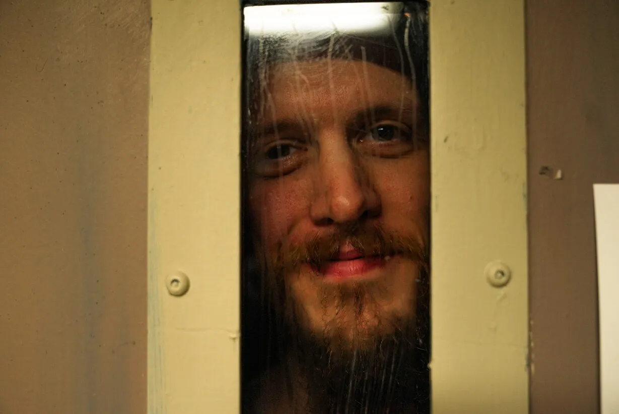 Man looking through prison cell door window