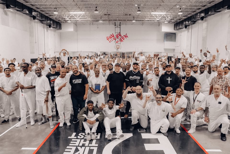 Large group of inmates in white gathered for prison event