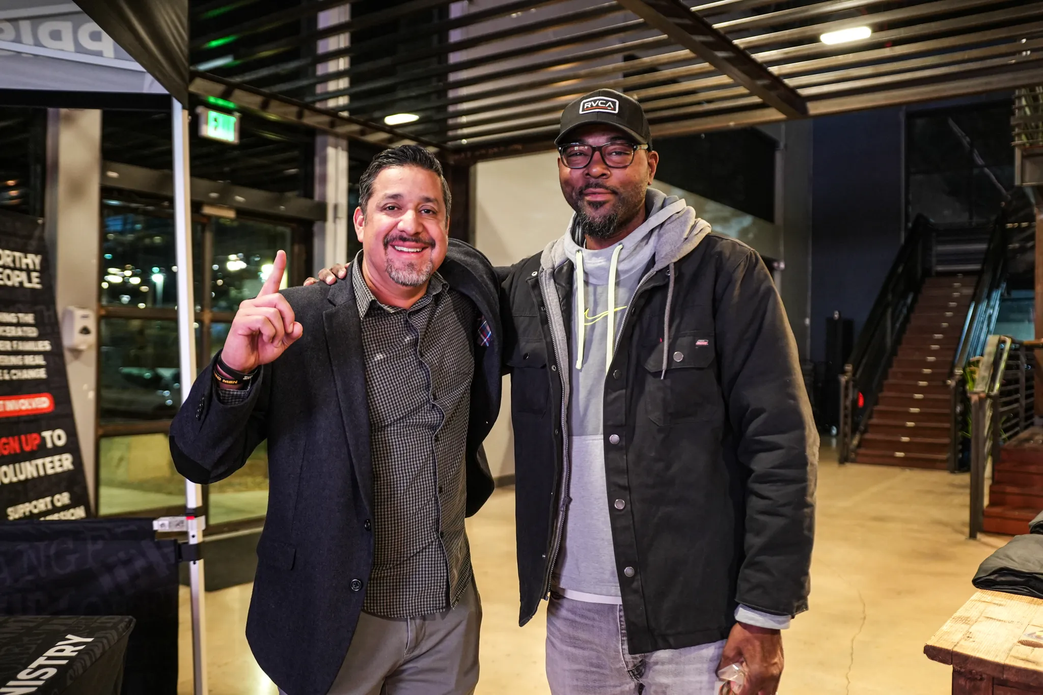 Two men smiling together outside Worthy People event