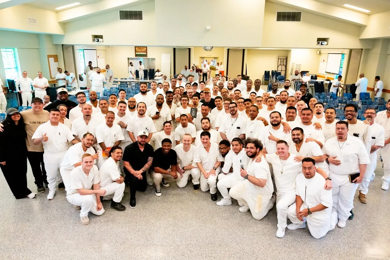 Large group of inmates and volunteers posing indoors