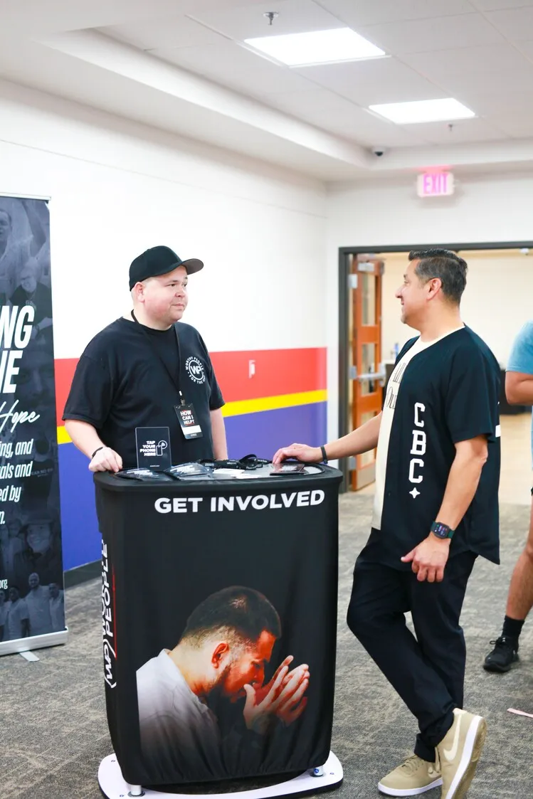Volunteer talking with visitor at Get Involved booth