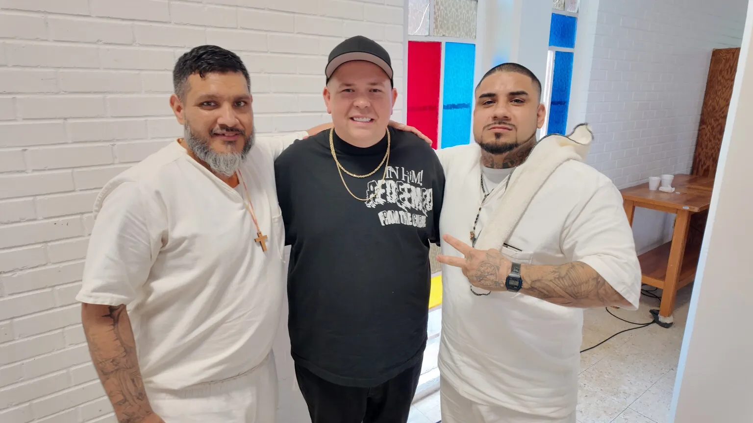 Three men smiling together in white and black shirts