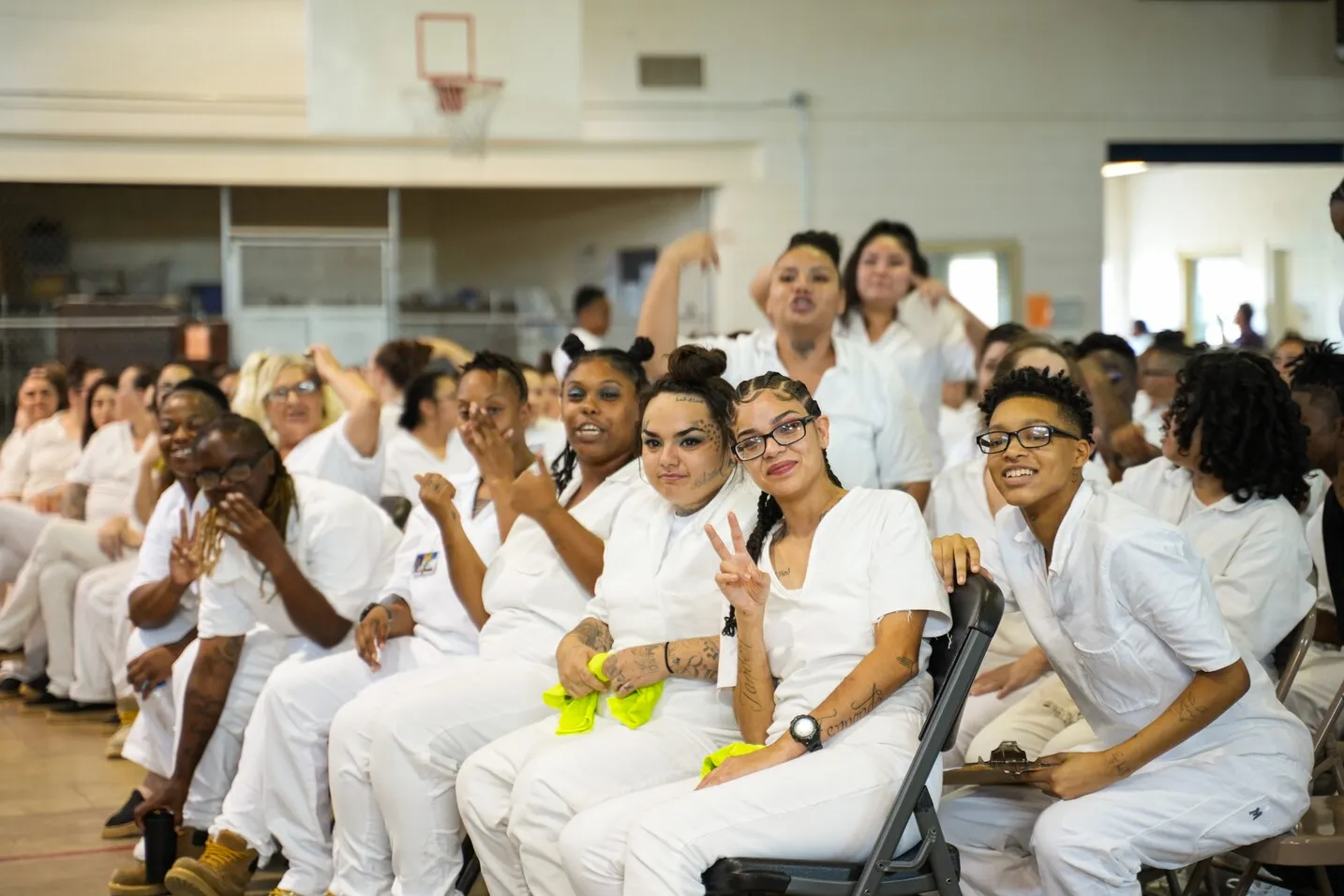 Women in white uniforms clapping during chapel service