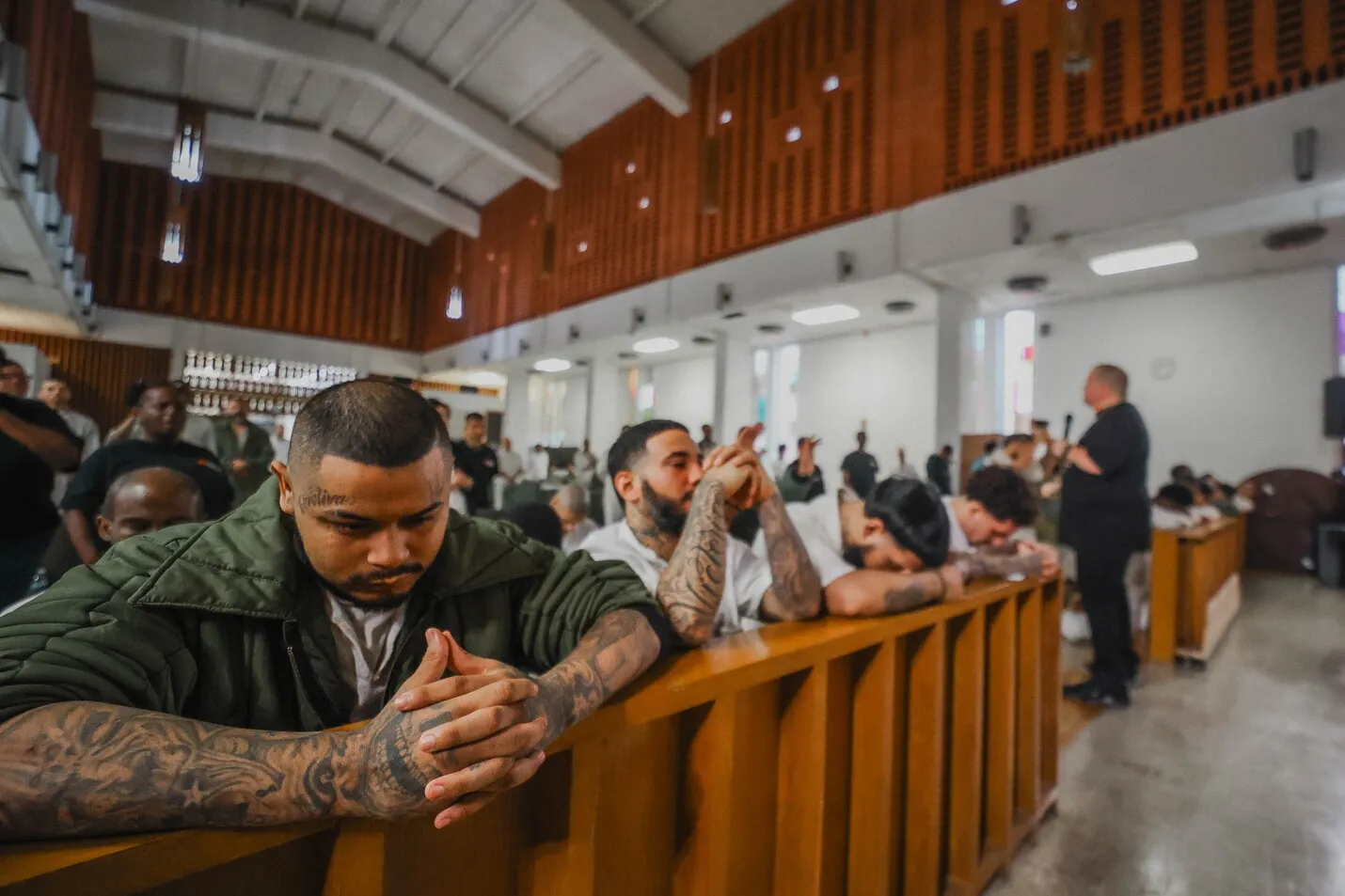 Inmate praying with hands clasped at chapel service
