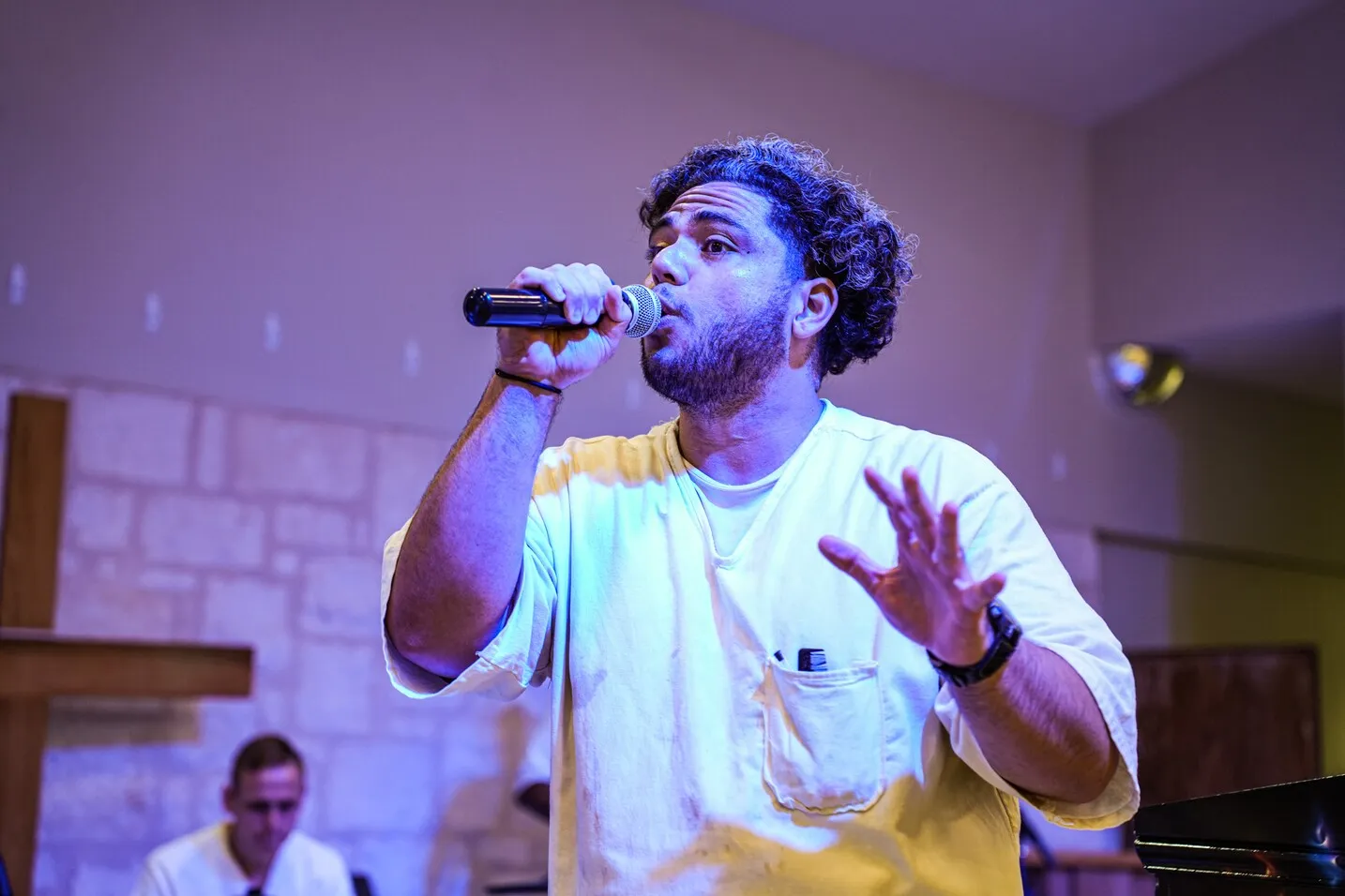 Man singing into microphone at prison chapel service
