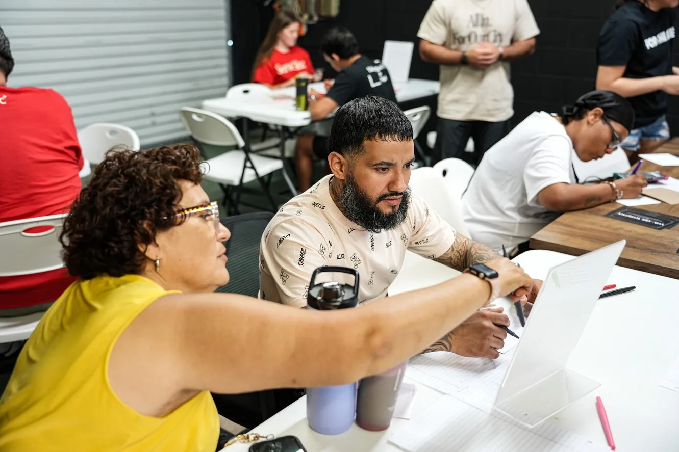 Woman helping man fill out re-entry paperwork at table