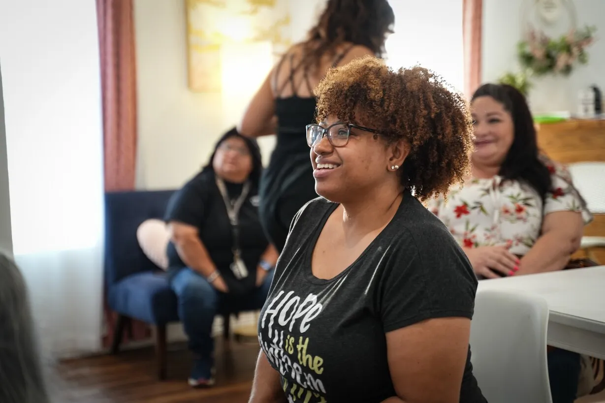 Woman smiling in group discussion wearing hope T-shirt