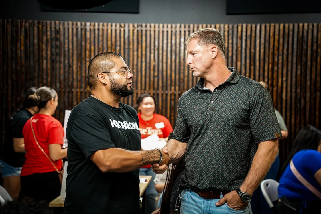 Two men shaking hands at Worthy People ministry event