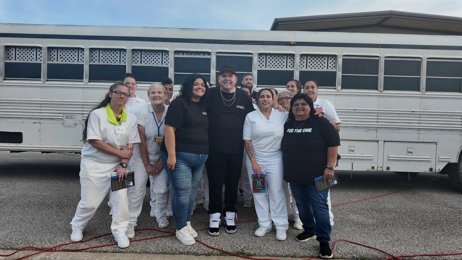 Worthy People volunteer team posing by prison transport bus
