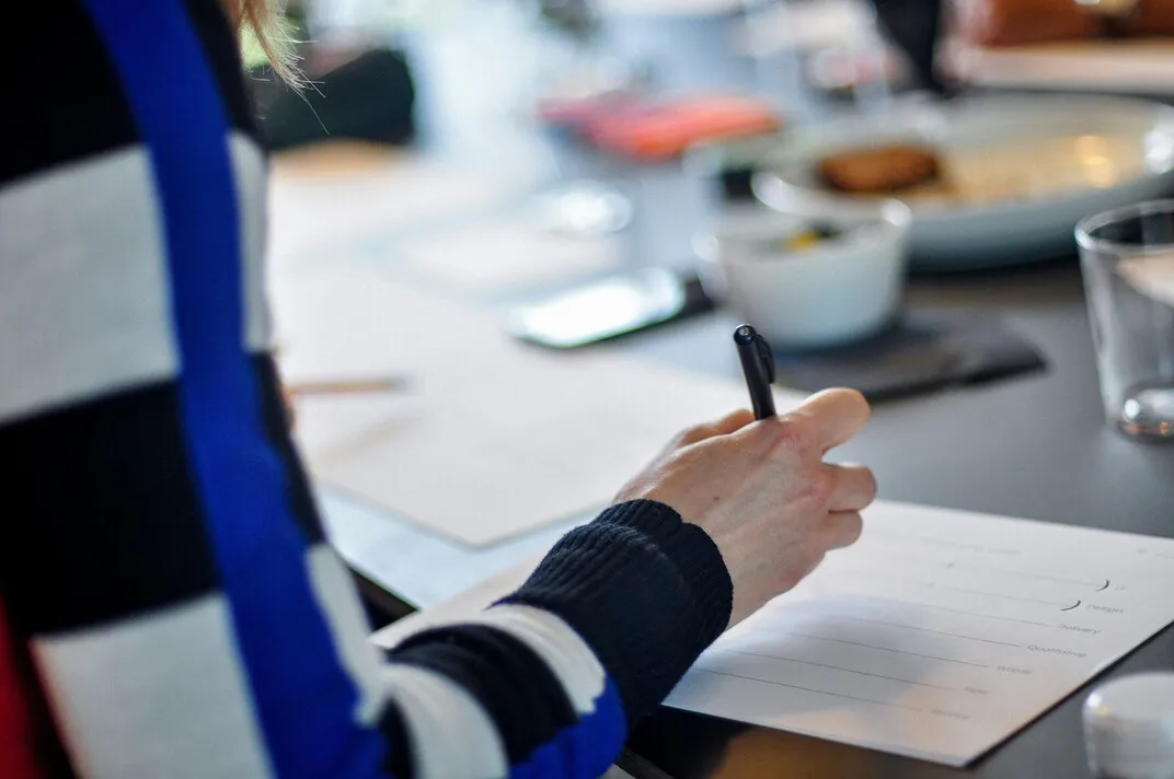 Person signing a document at a table