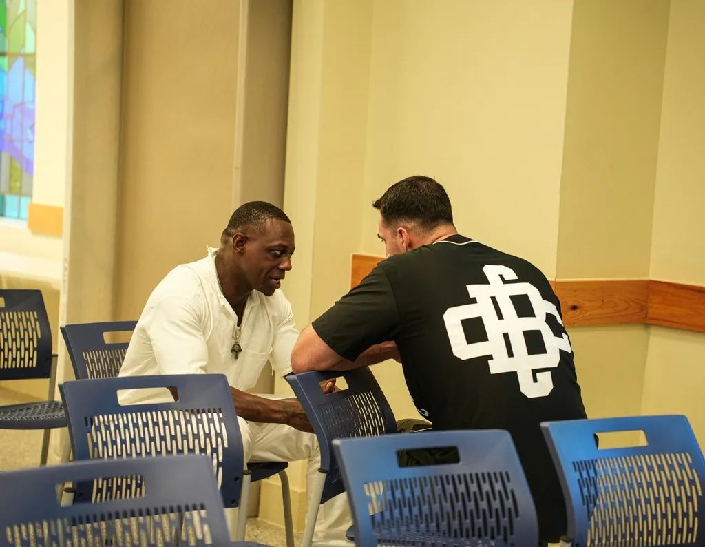 Volunteer praying with inmate in prison chapel