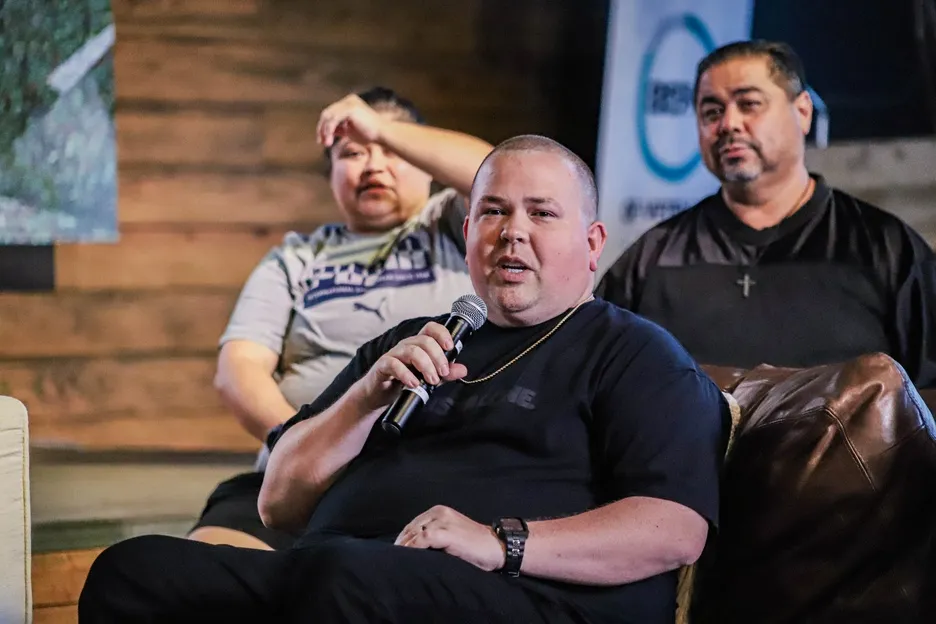 Man speaking into microphone during panel discussion