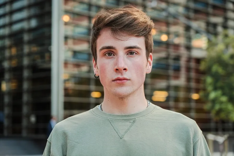Close-up portrait of young man outdoors near glass building