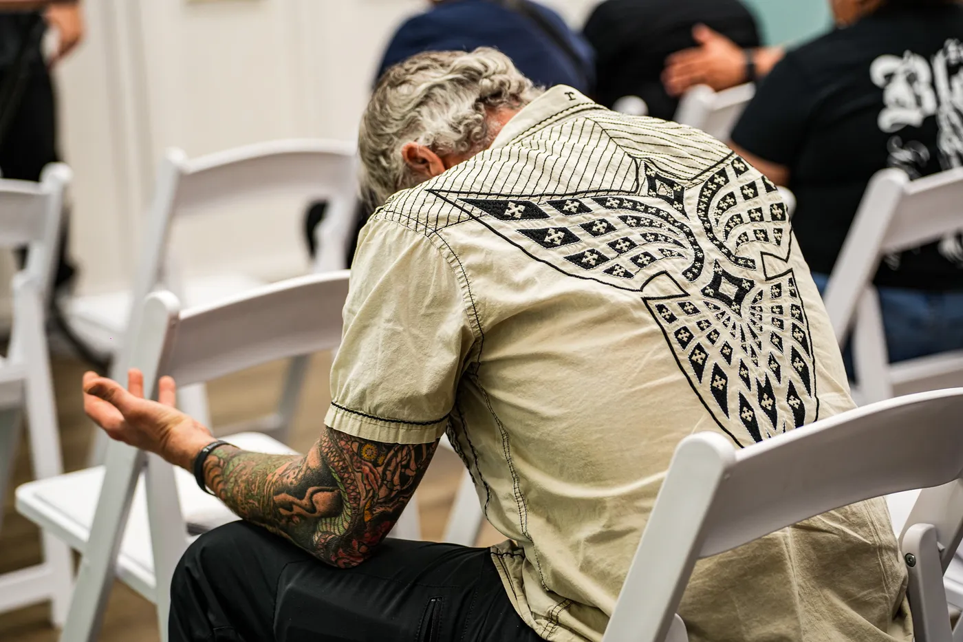 Man bowing his head in prayer at Worthy People event