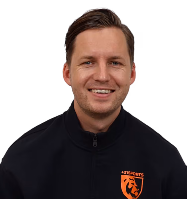 Smiling man with short hair wearing a black jacket with an orange lion logo and 31Sports text.