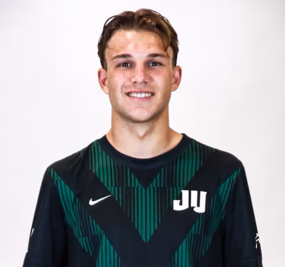 Smiling young man wearing a black and green sports jersey with a white JU logo.