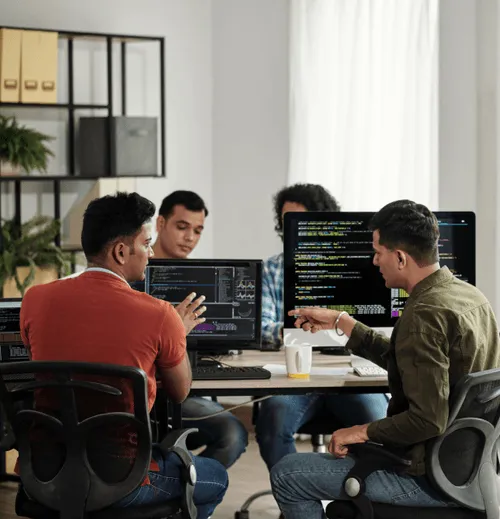 Nearshore POD software development team at a shared desk.