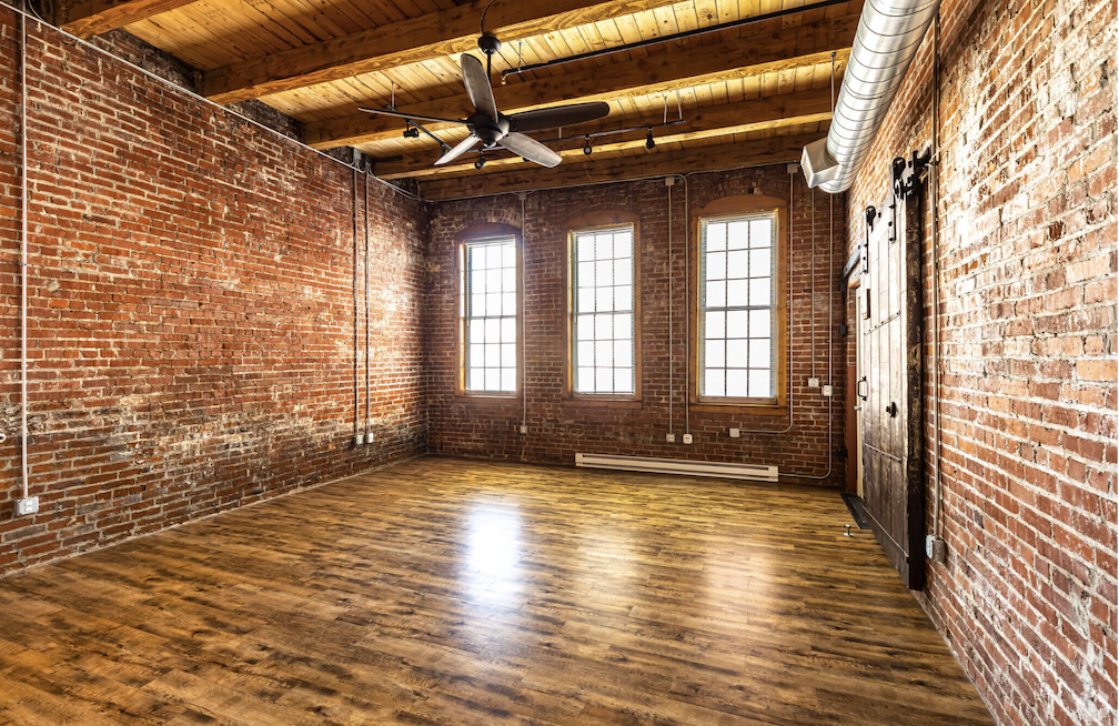 living room with brick walls and wood flooring