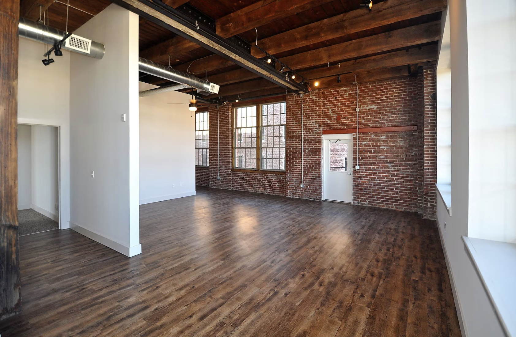 living room with brick walls and wood flooring