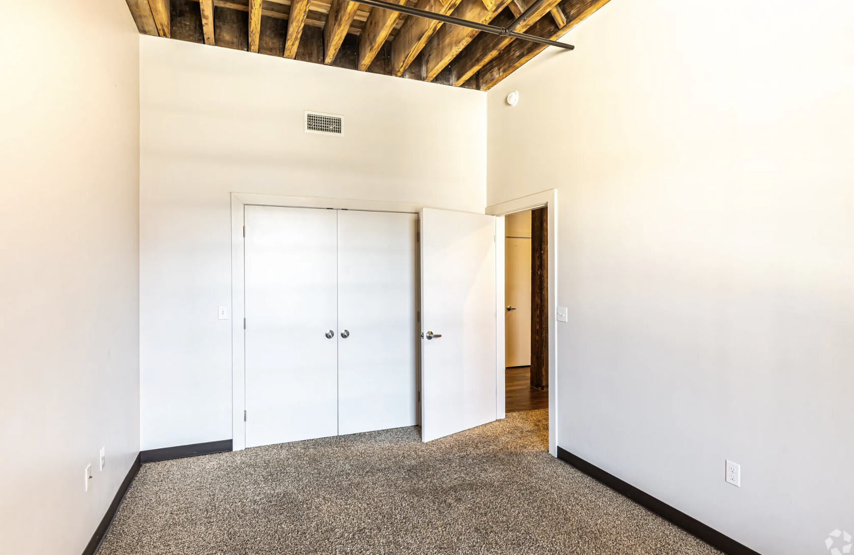 Bedroom with white wall, closet and carpet