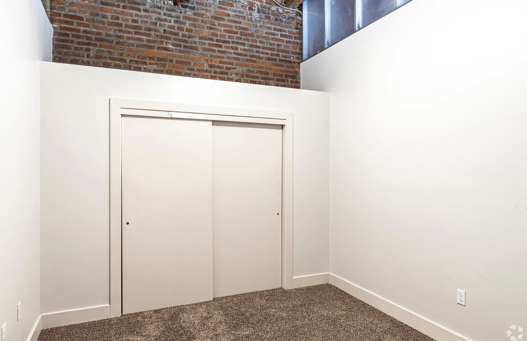 Bedroom with white wall, closet and carpet