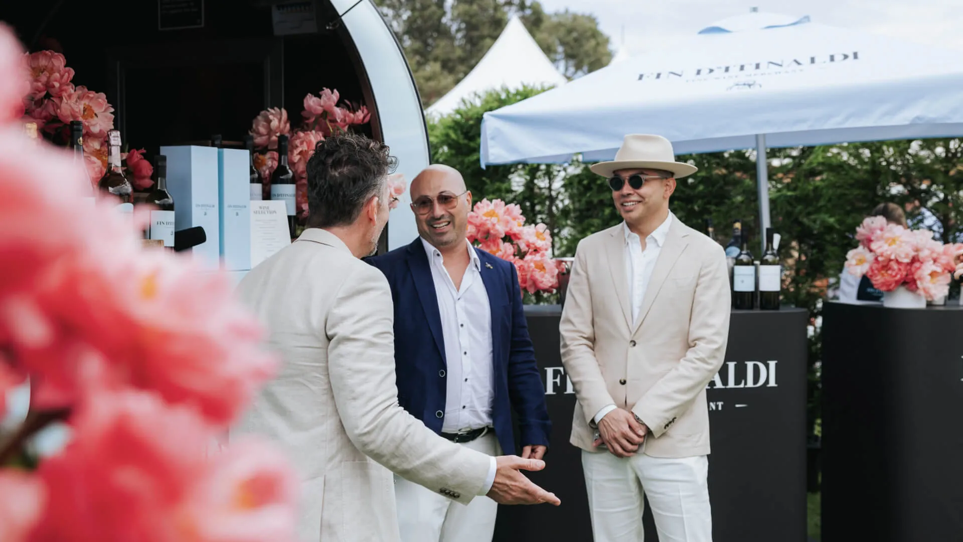 Guests talk beside a floral display at the outdoor wine activation.