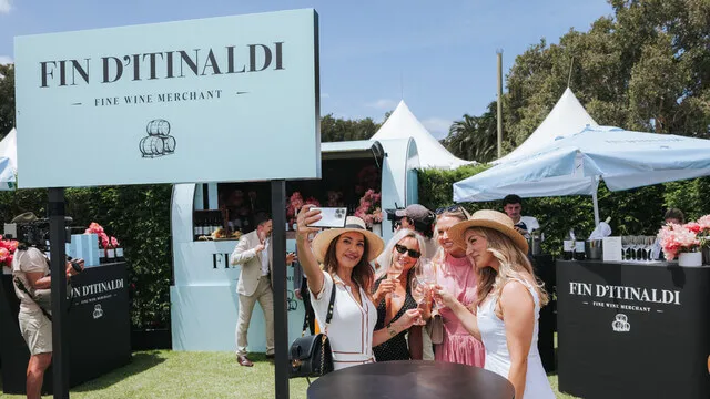 Guests pose beneath a Fin D’Itinaldi sign at the wine activation.