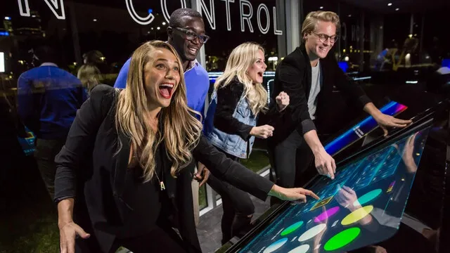 Visitors interact with the colourful control table beneath IN CONTROL lettering.