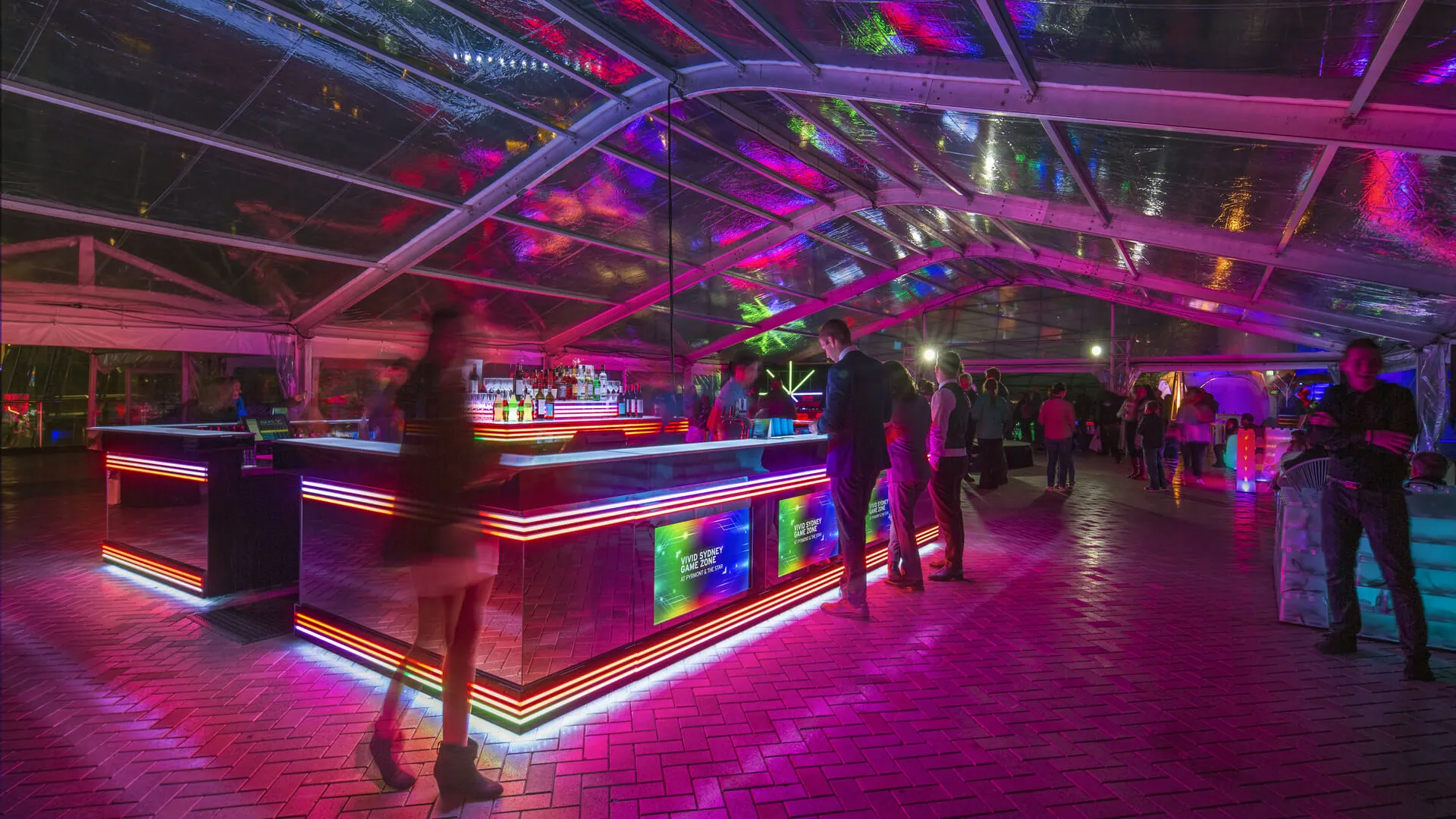 Visitors walk through a neon-lit indoor installation at The Star during Vivid.