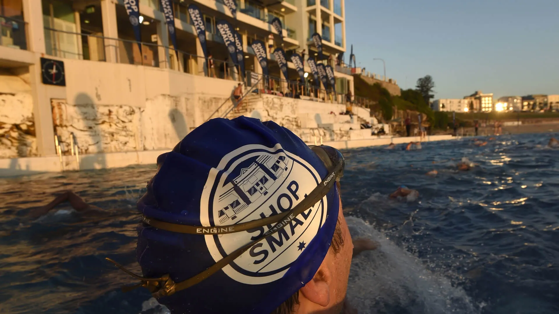 Swimmer wearing a blue Shop Small cap in the ocean pool.