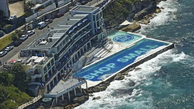 Aerial view of the ocean pool covered with blue Shop Small branding.