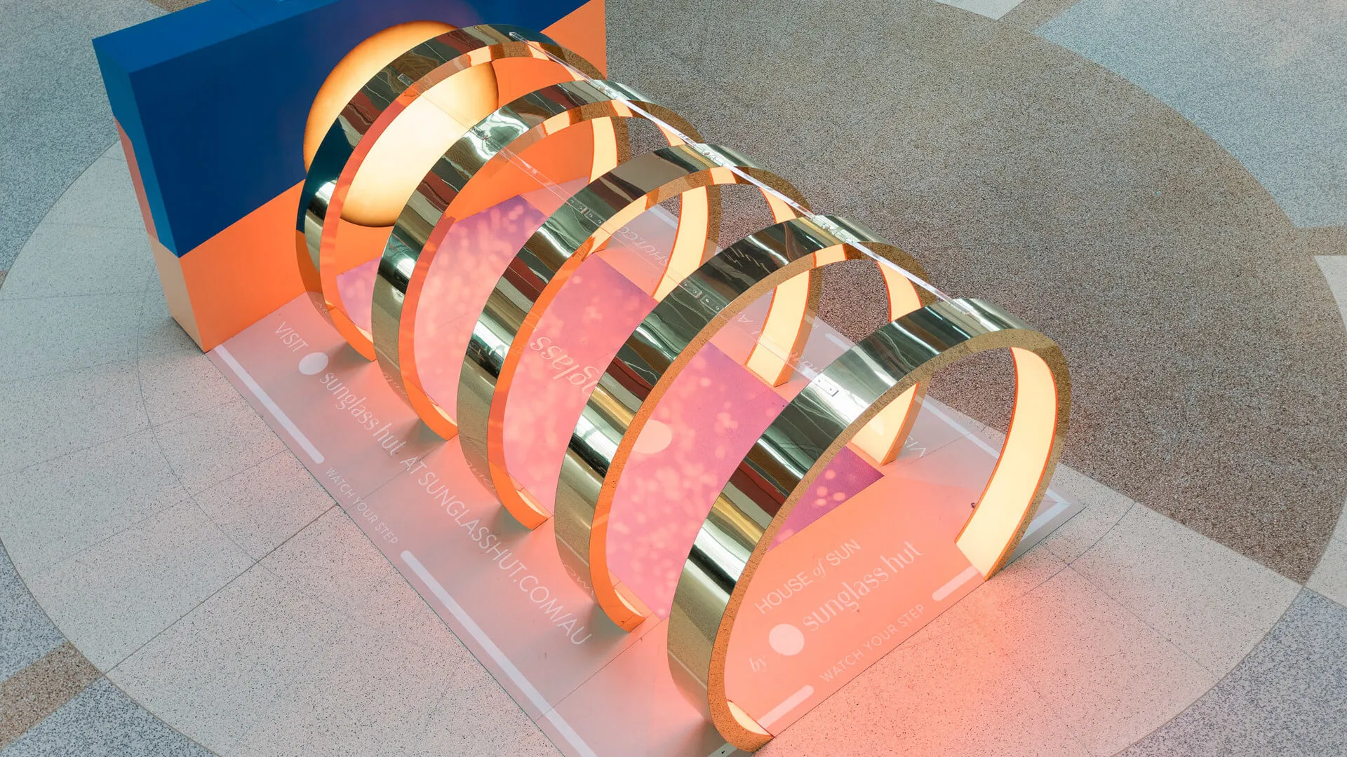 Overhead view of the illuminated gold-and-pink House of Sun arches.