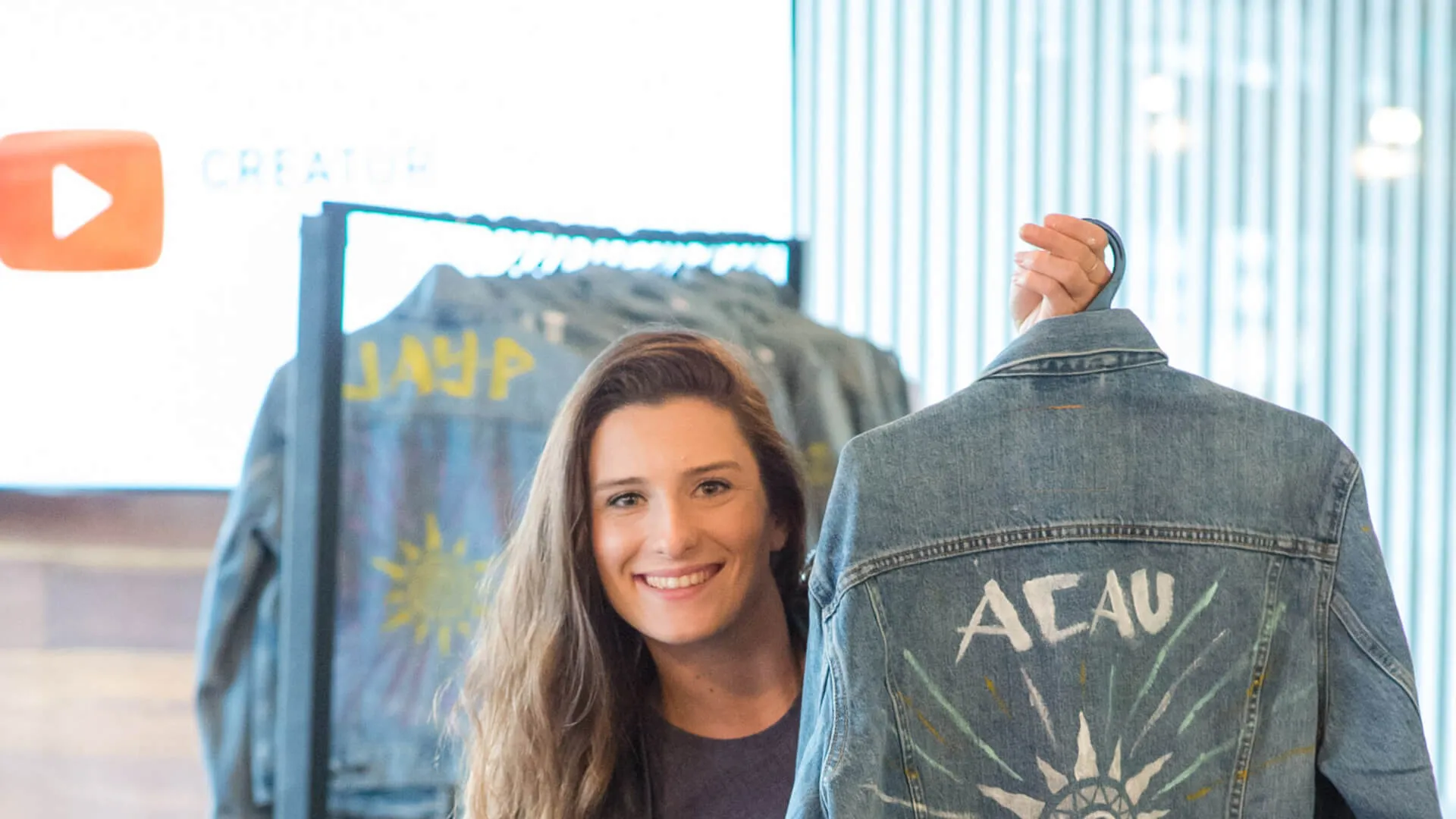 Guest holds a decorated denim jacket at the YouTube Creator Summit.
