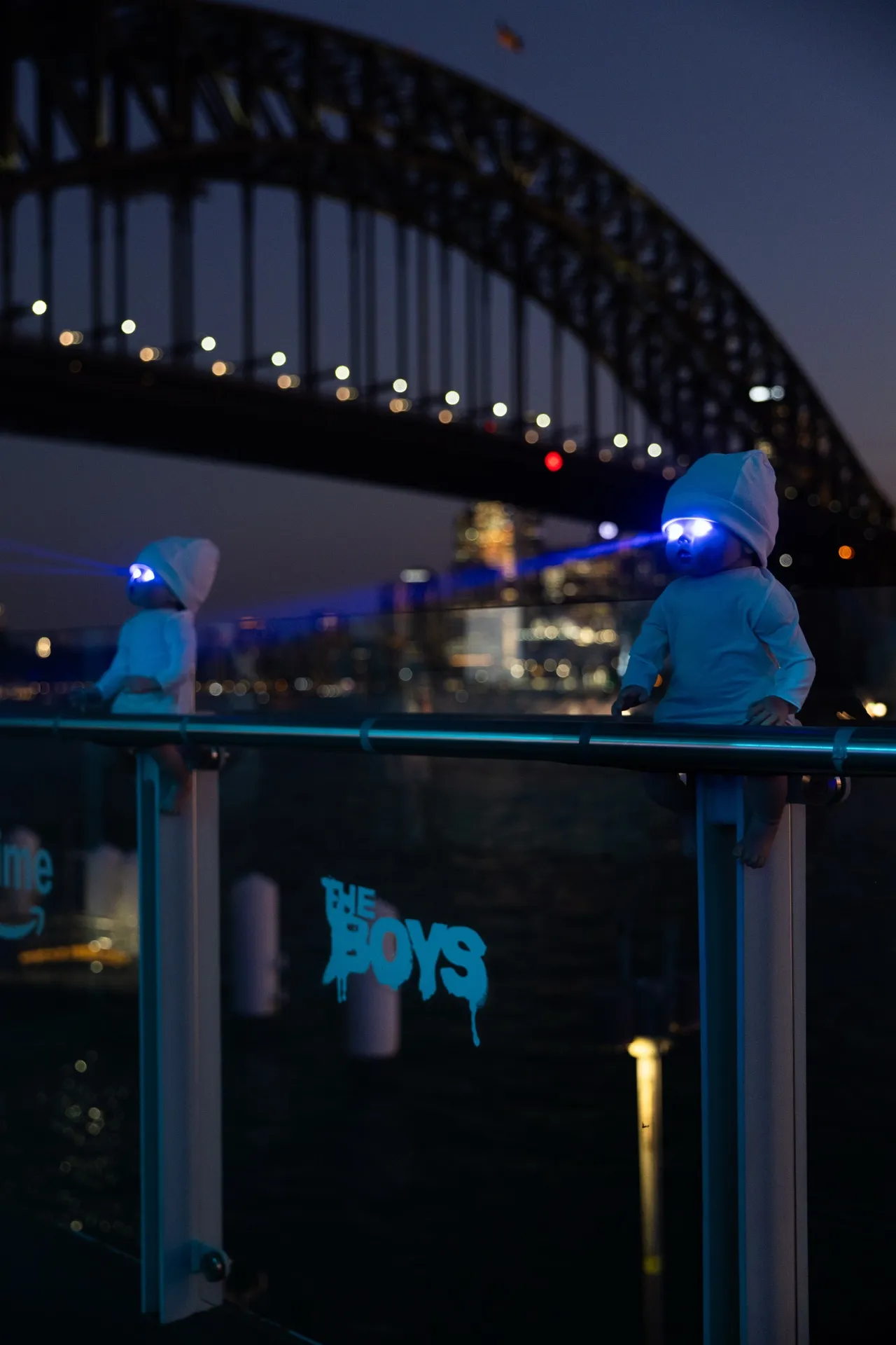 The Boys event branding beside Sydney Harbour Bridge at night.