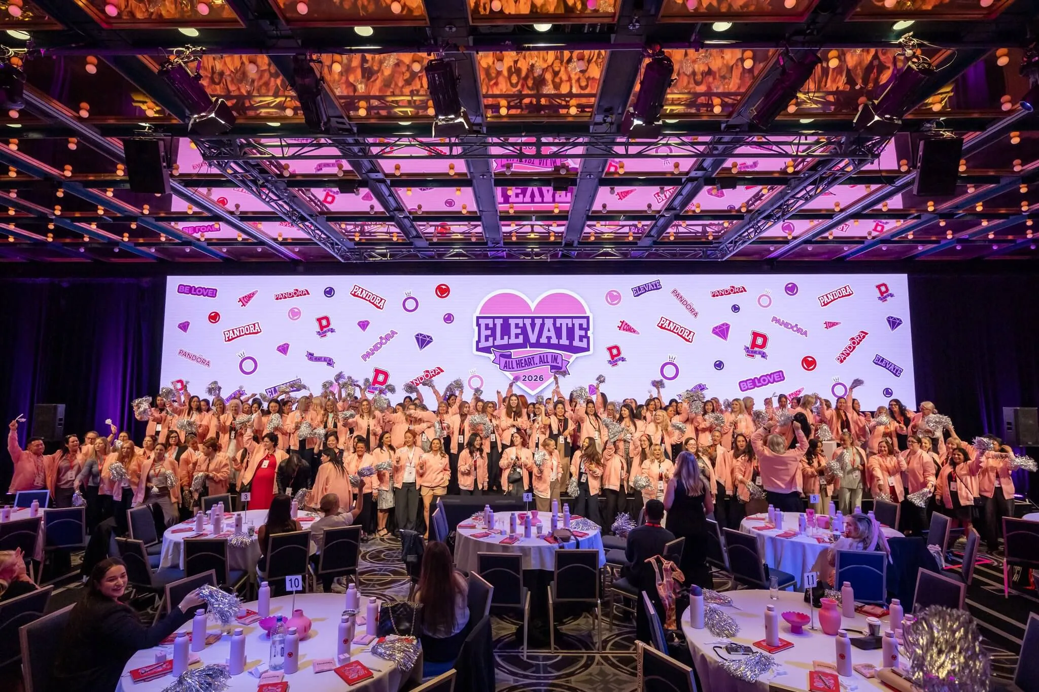 Large group of Pandora conference attendees poses in front of the ELEVATE stage.