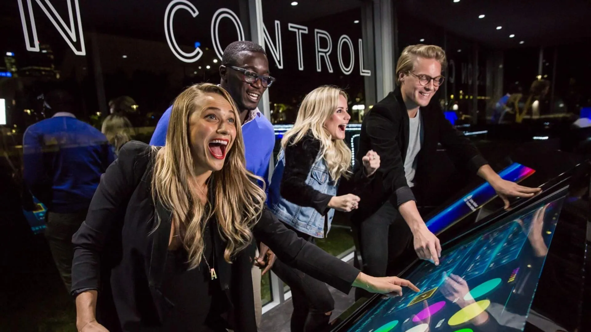Visitors interact with a colourful illuminated control table at Vivid.