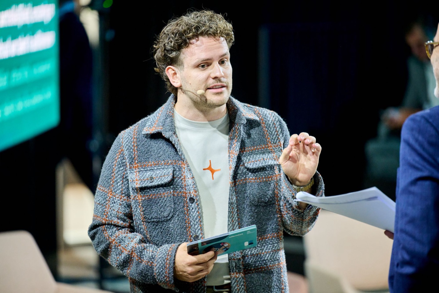 dr. Mathias Celis in conversation with a host on stage
