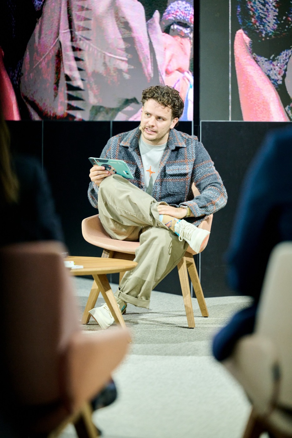 dr. Mathias Celis seated on stage during a panel