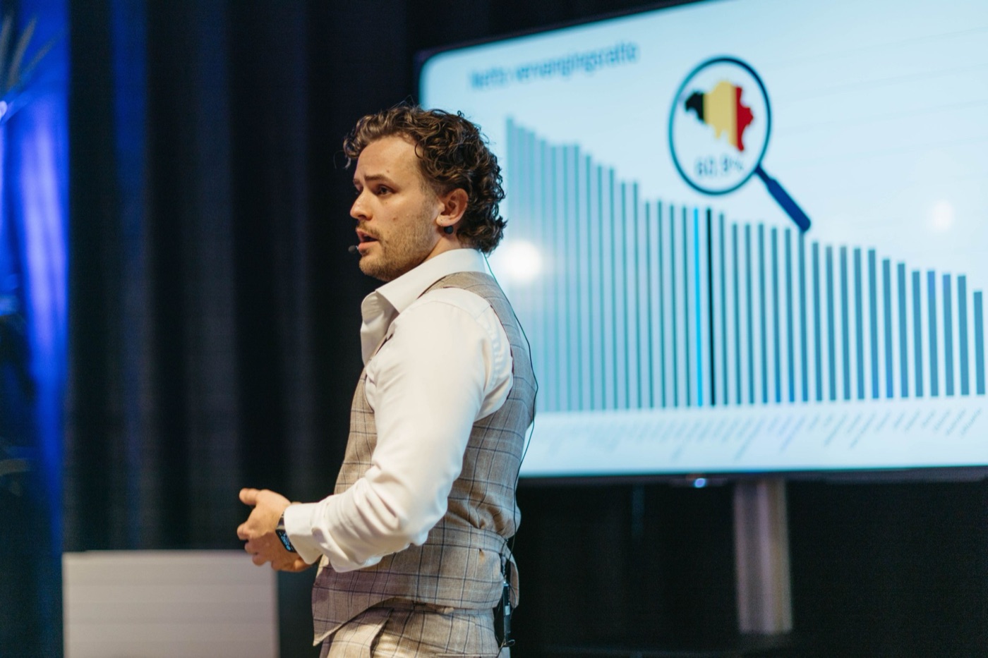 dr. Mathias Celis presenting a chart on stage