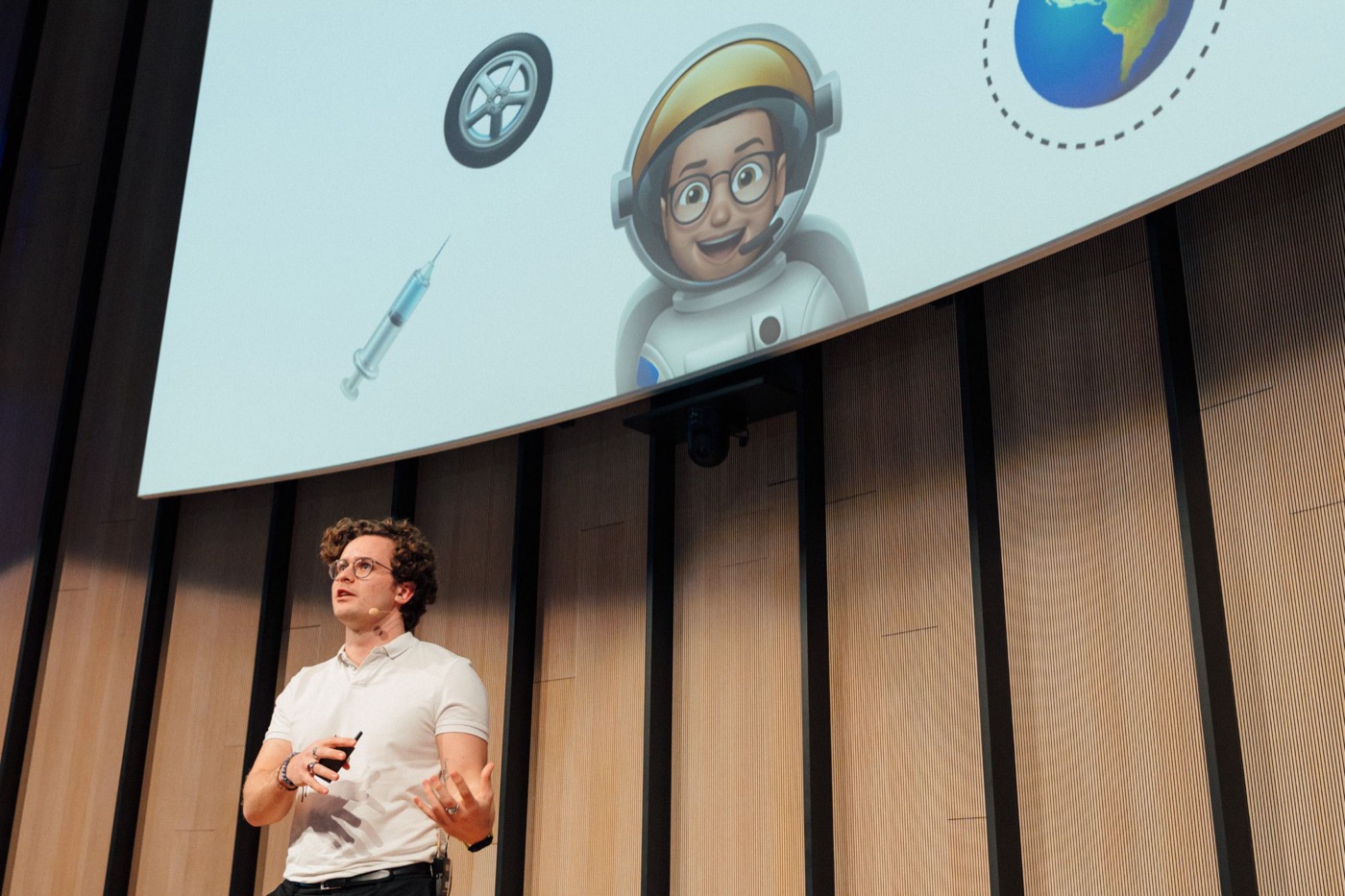dr. Mathias Celis on stage under a large slide of an astronaut