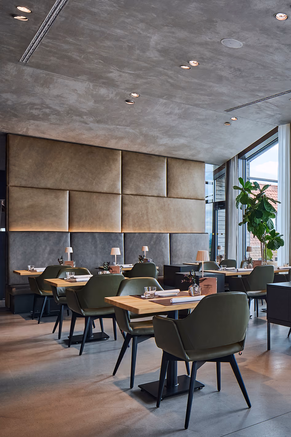 Gastraum des Restaurants JOHANNS mit grünen Stühlen und Holztischen