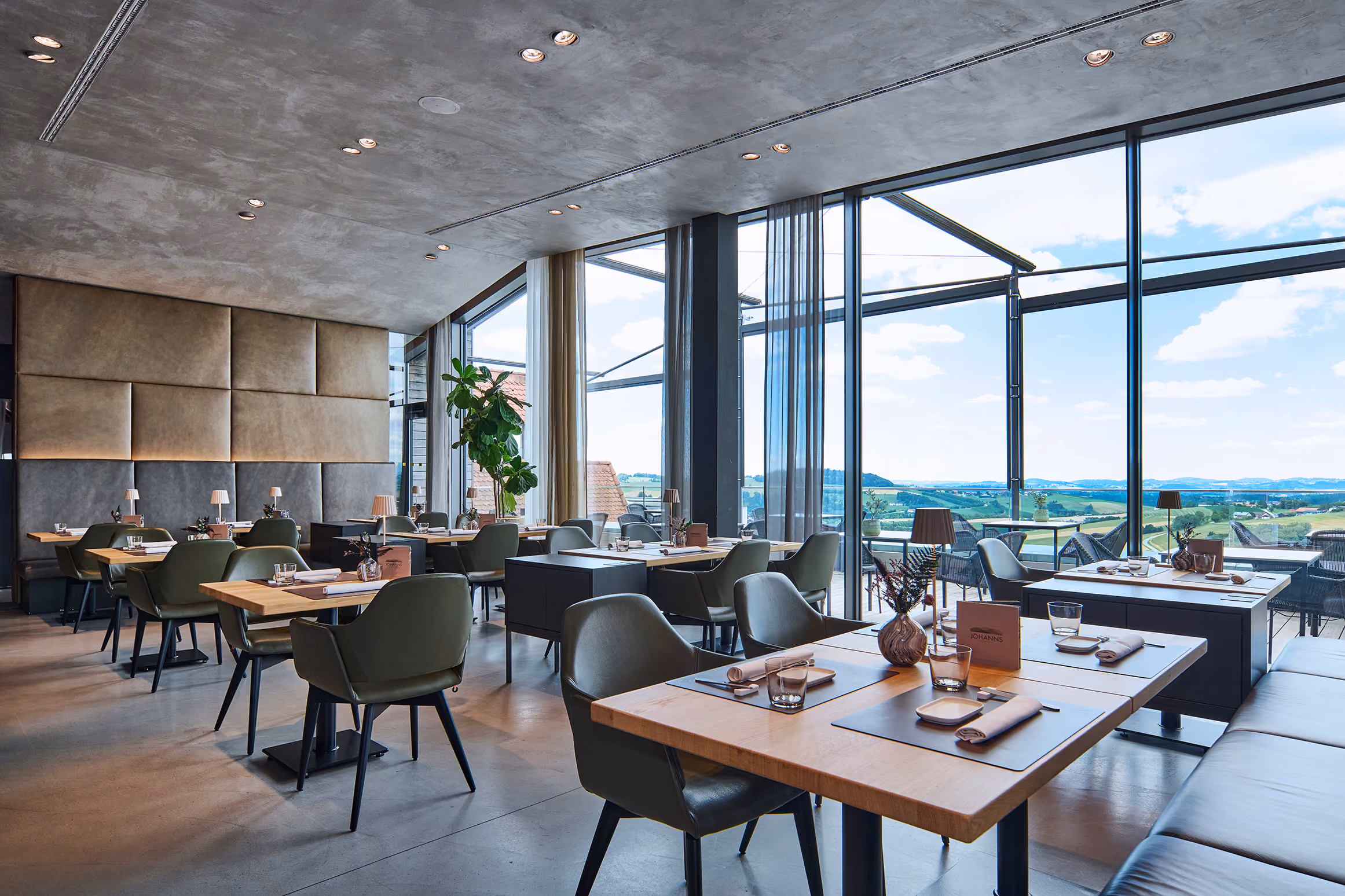 Gastraum des Restaurants JOHANNS mit Panoramafenstern und Blick ins Grüne