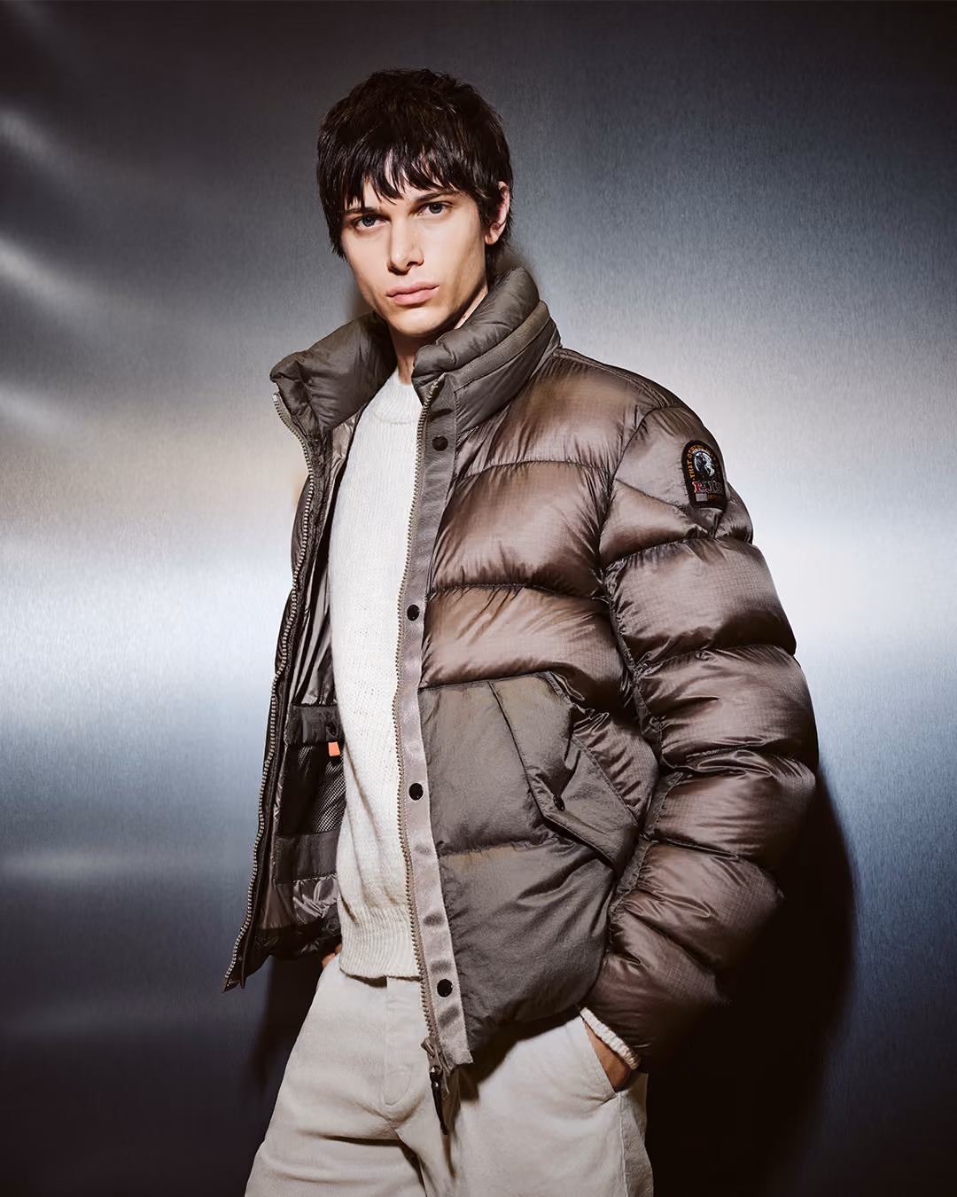 Model in brauner Daunenjacke und hellem Pullover