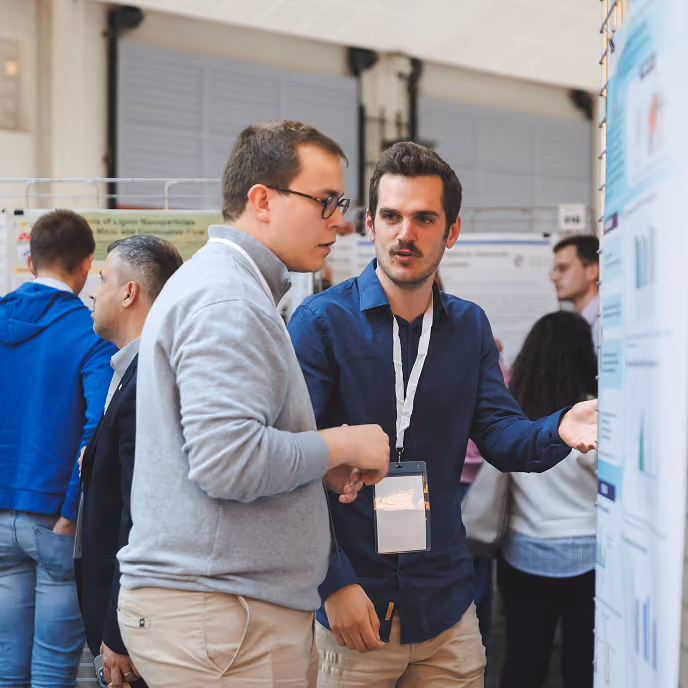 Two men discussing a scientific poster presentation at a conference or academic event.