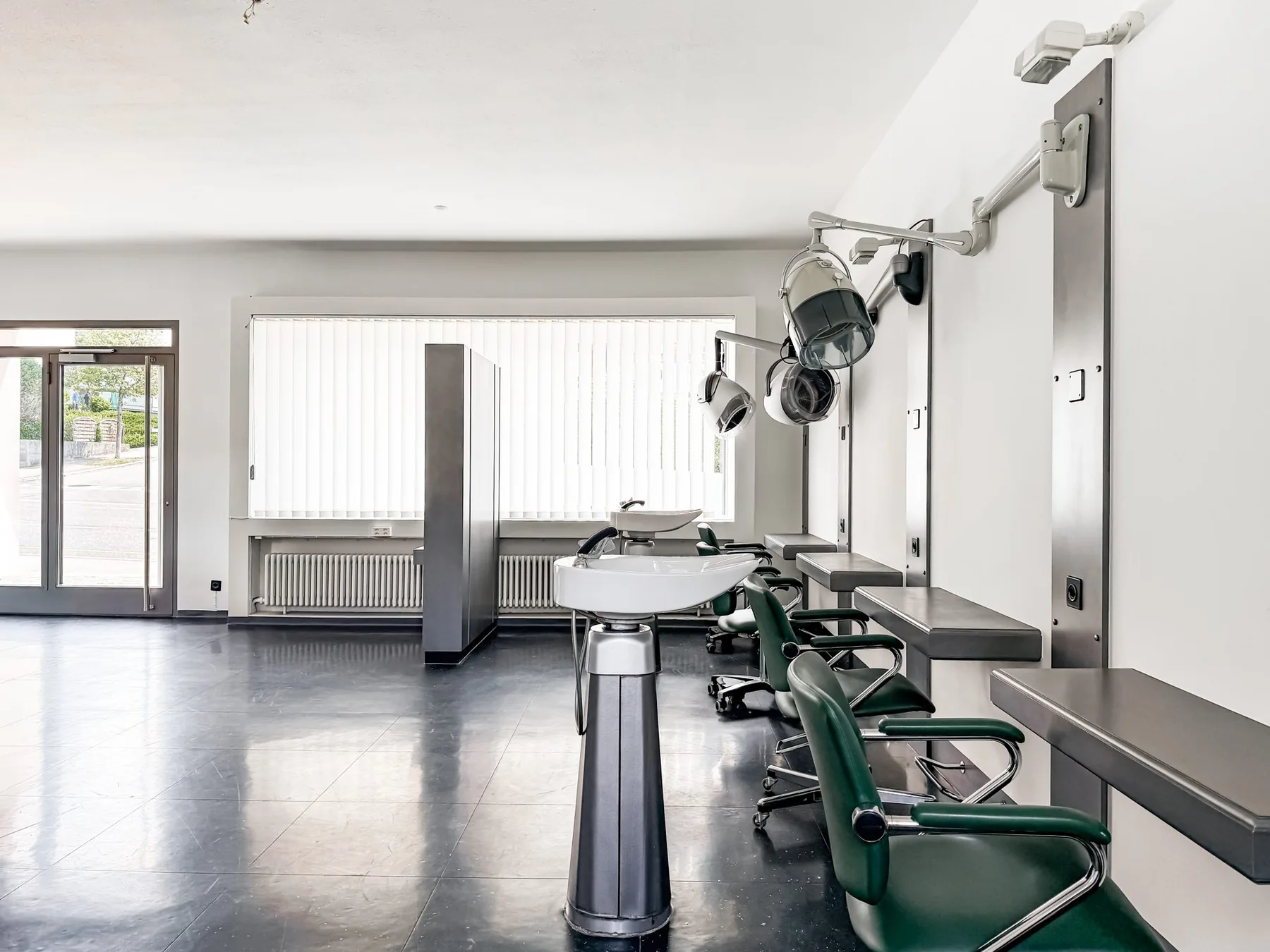 Arbeitsplätze mit grünen Stühlen entlang der Wand im Gewerberaum an der Witikonerstrasse 423