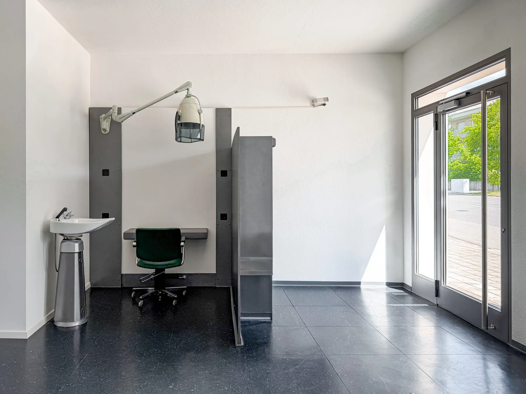 Einzelner Arbeitsplatz neben der verglasten Eingangstür im Gewerberaum an der Witikonerstrasse 423