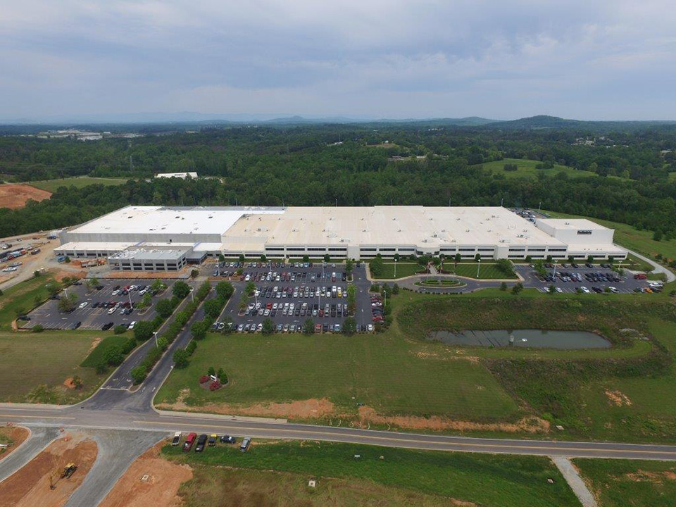 Aerial view of Reliable Automated Sprinkler Company's large flat-roofed facility and parking lot