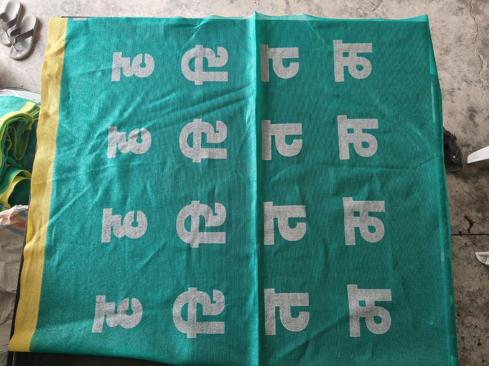 Custom printed green shade net displaying repeated Haritam project identification
